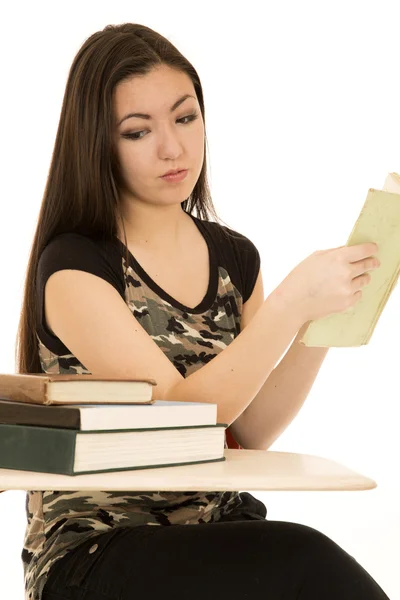 Girl student looking at pile of books on her desk — Stock Photo, Image