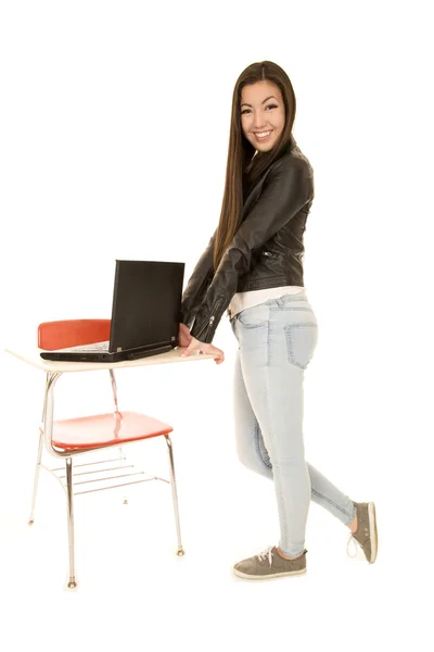 Cute young woman standing by desk with computer — Stock Photo, Image
