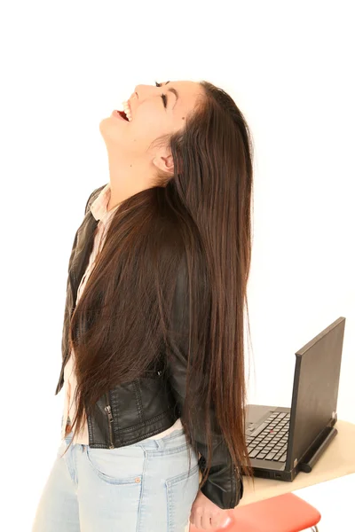 Cute teen girl by computer with her head back laughing — Stock Photo, Image