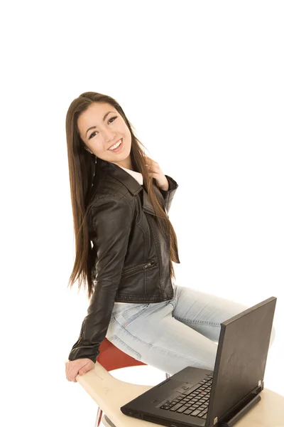 Casual teenage girl sitting by computer smiling — Stock Photo, Image