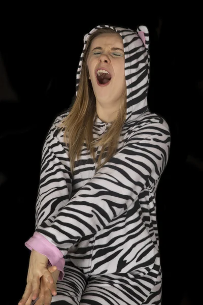 Young woman wearing cat pajamas in a deep yawn — Stock Photo, Image