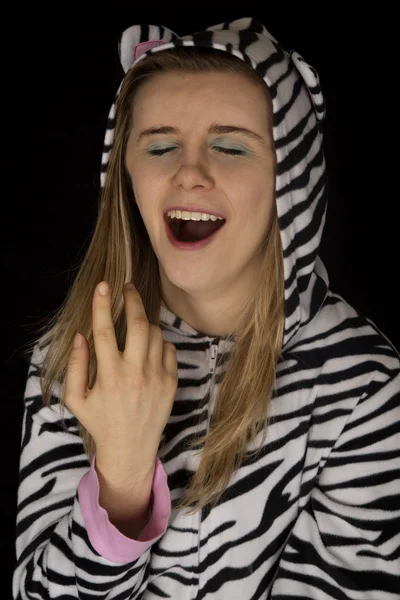 Närbild porträtt av en ung kvinna gäspar i katt pyjamas — Stockfoto