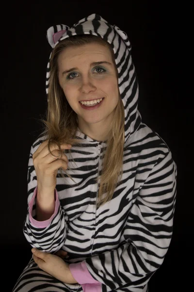 Young woman wearing cat pajamas playing with her hair — Stock Photo, Image