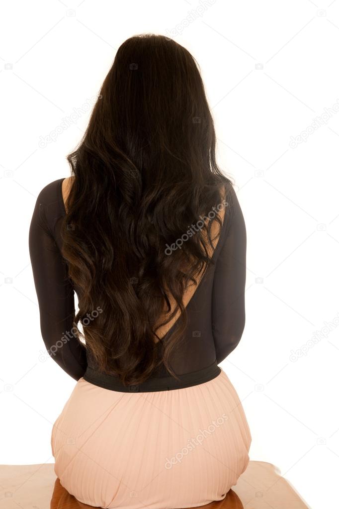 Back view of a female sitting down with long brunette hair
