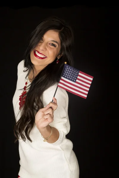 Mulher de cabelos escuros sorrindo segurando uma bandeira americana — Fotografia de Stock