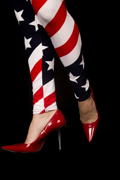 Womens legs wearing flag leggings and red high heels — Stock Photo, Image