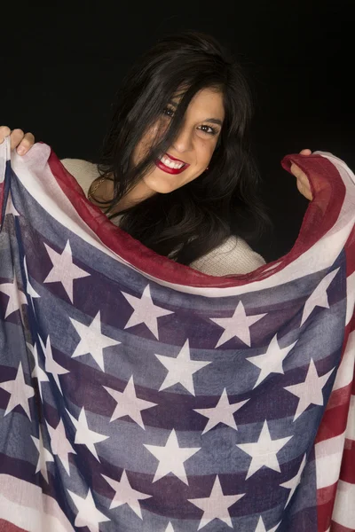 Linda mujer de complexión oscura sosteniendo una bufanda de bandera americana smilin —  Fotos de Stock