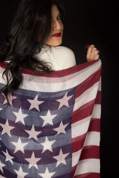 Mulher segurando bandeira americana cachecol eterno olhando sobre seu shoul — Fotografia de Stock