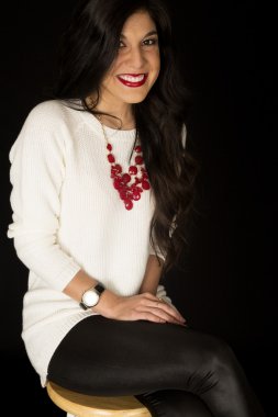 Oldukça karanlık bir tabure gülümseyerek oturan kadın