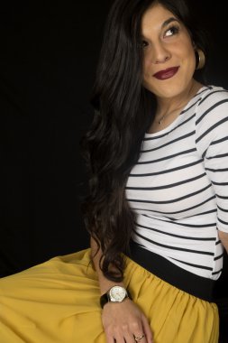 Sarı etek siyah backgrou kadar seyir aşağı oturan güzel kadın