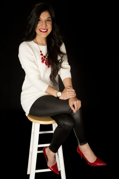 Beautiful woman semi casual dressed sitting on a bar stool — Stock Photo, Image