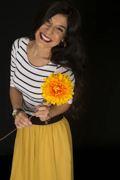 Joyeux beau modèle féminin tenant une grande fleur jaune souriant — Photo