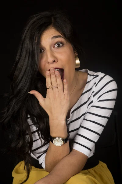 Beautiful woman with a surprised expression sitting down — Stock Photo, Image