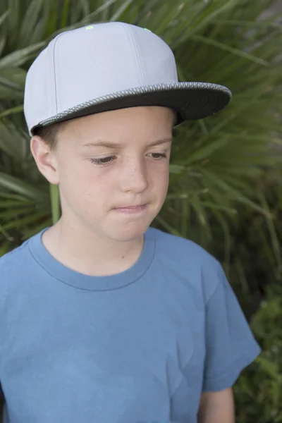 Молода чоловіча модель в сірому бейсбольному капелюсі думає про понду — стокове фото