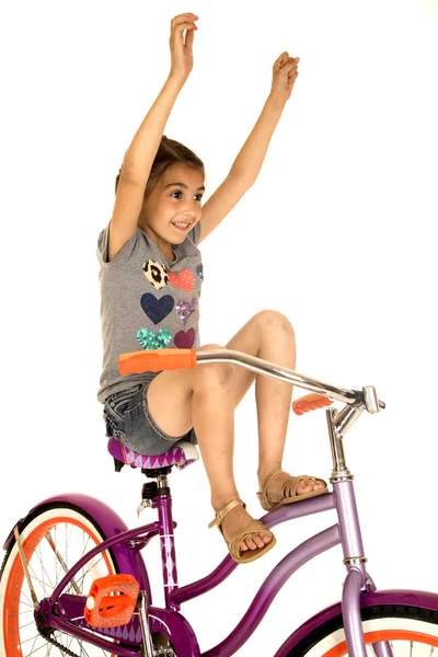 Cute girl riding a bicycle with her hands in the air — Stock Photo, Image