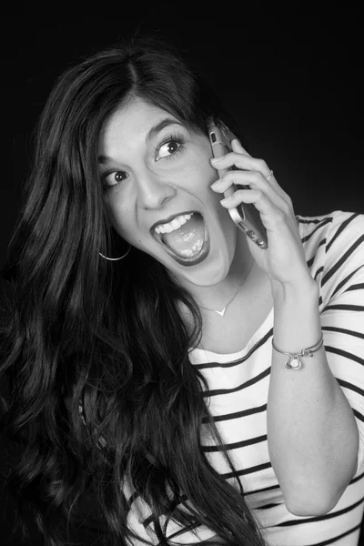 Excited beautiful brunette woman talking on her cell phone black — Stock Photo, Image