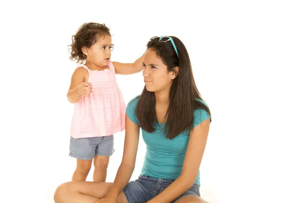 Cute toddler girl reaching for teenage sister's sunglasses — Stock Photo, Image