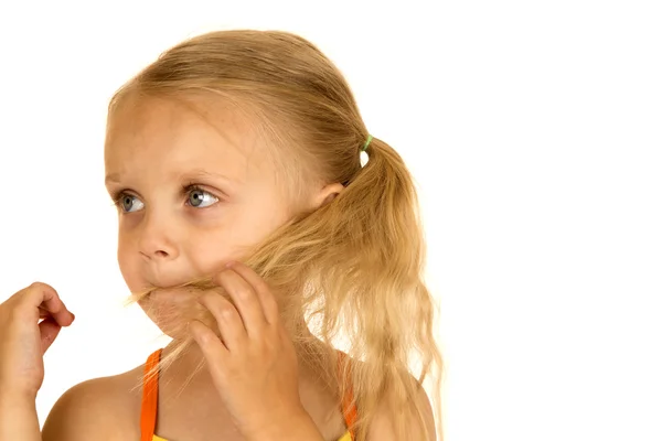 Blond meisje speelt met haar haar in haar mond — Stockfoto