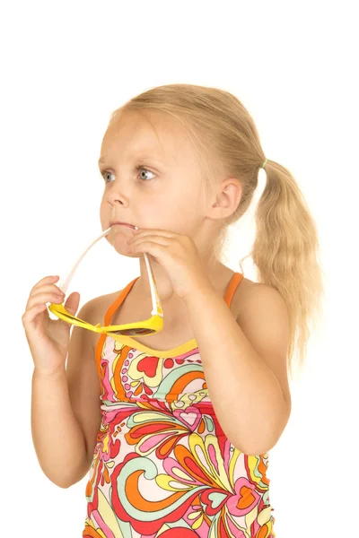 Cute blond girl playing with sunglasses in her mouth — Stock Photo, Image