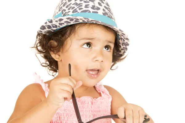 Hispanic toddler girl holding glasses wearing hat — Stock Photo, Image