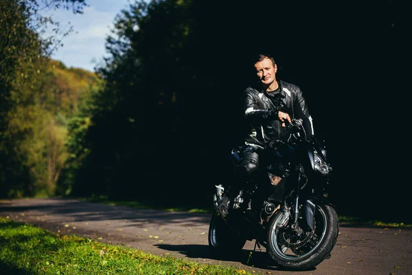 Muž Černé Sportovní Motorce Černém Koženém Oblečení Silnici Lese — Stock fotografie