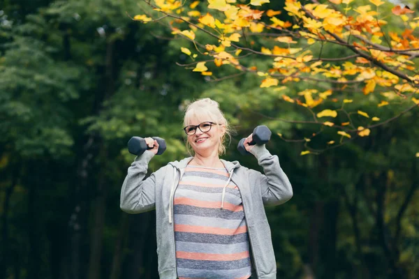 Schöne Seniorin Beim Spaziergang Park Macht Übungen Mit Hanteln Der — Stockfoto