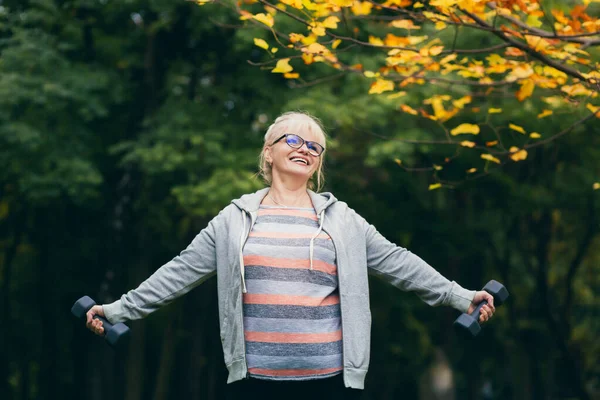 Schöne Seniorin Beim Spaziergang Park Macht Übungen Mit Hanteln Der — Stockfoto