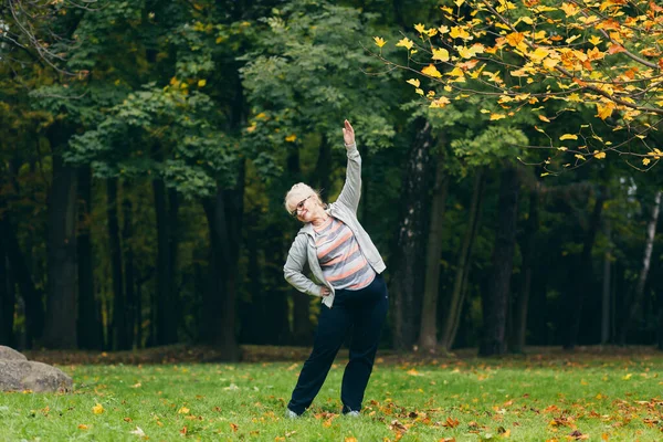 Vacker Äldre Kvinna Promenad Parken Utför Övningar Stående Gräset Morgon — Stockfoto