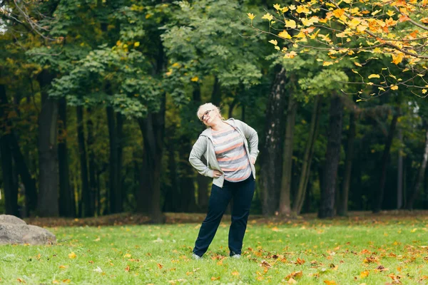 Vacker Äldre Kvinna Promenad Parken Utför Övningar Stående Gräset Morgon — Stockfoto