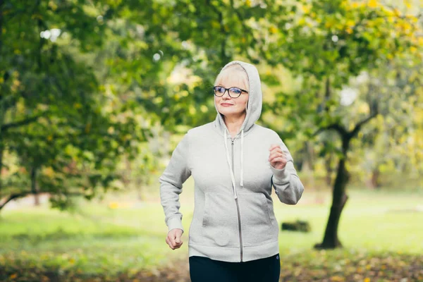 Schöne Seniorin Rucksack Auf Einem Spaziergang Park Musik Mit Kopfhörern — Stockfoto