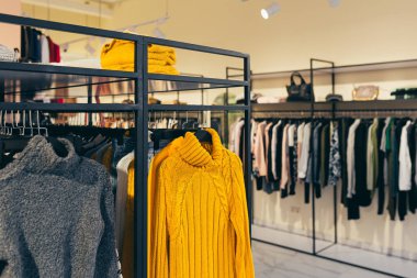 Modern bir mağazada giysiler, askılar, farklı renkler, modern tarz.