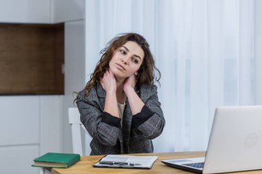 Yorgun ve uykulu kadın dizüstü bilgisayarla çalışıyor, evde ya da ofiste, internette çalışıyor.