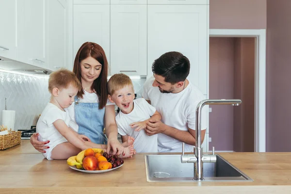 快乐的家庭 快乐的丈夫和两个孩子 在厨房里吃早餐 快乐地在一起度过 — 图库照片