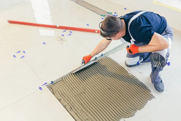 Trabajador Construcción Instala Una Gran Baldosa Cerámica — Foto de Stock