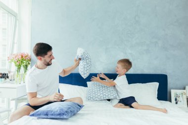 Koca baba çocuklarıyla oynuyor, iki küçük erkek kardeş, büyük bir yatak odasında.