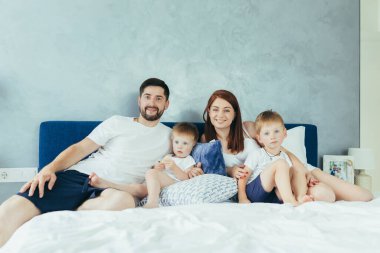 Genç bir aile eşi ve iki küçük çocuk, oğullar, yatak odalarında birlikte eğlenin.