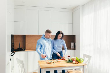 Sporcu koca, sebzelerden karısına öğle yemeği hazırlar, mutfakta birlikte vakit geçirir.