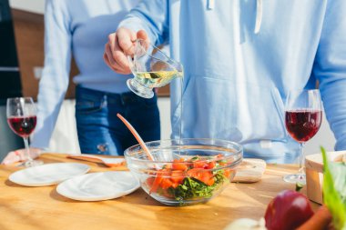 Yakın plan fotoğraf, eller sebzeleri salataya kesiyor.