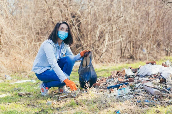 若い女性ボランティアが森や公園でプラスチックごみを集め ボランティアがビニール袋を持ってゴミを集める — ストック写真