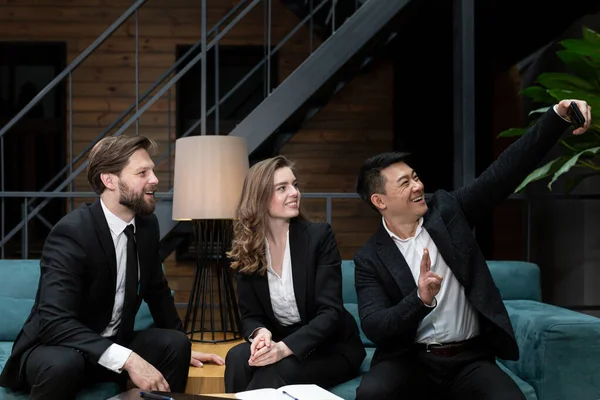 Bir grup insan video iletişimi için telefon kamerası kullanıyor, iş adamları iş toplantısı yapıyor, erkek ve kadın.