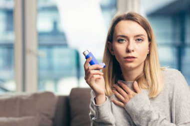 Güzel kız astım spreyini tutarken