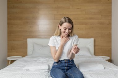 Hamilelik testi yapan mutlu, heyecanlı genç bir kadın neşe dolu sonuçlara bakıyor. Yatak odası, döllenme.