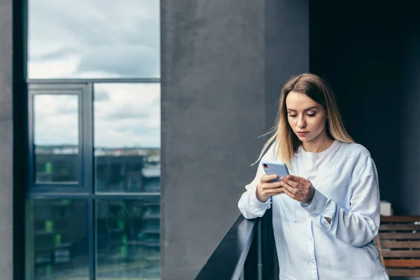 Beautiful Blonde Woman Uses Mobile Phone While Standing Balcony Apartment — Stock Photo, Image