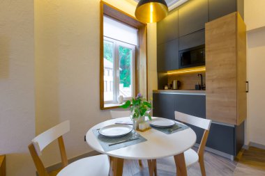 İç fotoğrafçılık, çatı katı tarzı, sıcak aydınlık ve karanlık mutfağı olan küçük bir daire.