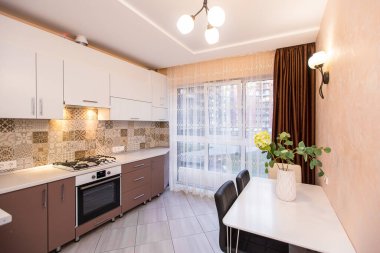 Pastel renkli, gri renkli, içinde siyah mermer olan modern bir mutfak.