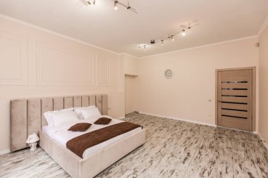 İç görüntü, yatak odası, küçük bir stüdyo daire, büyük bir yatak ve beyaz duvarlar.