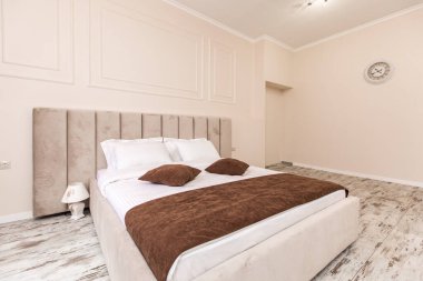 İç görüntü, yatak odası, küçük bir stüdyo daire, büyük bir yatak ve beyaz duvarlar.