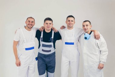 İnşaat işçileri, dört kişi, inşaat ve onarım işi yapan adamlar kameraya bakıyor.