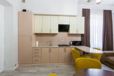 Modern bir mutfağın içi, pastel renklerde güzel bir tasarımı olan büyük bir oda, gri ve sarı.