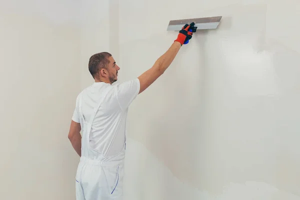 Trabajador Hombre Enyesa Pared Con Una Espátula Aplica Una Solución — Foto de Stock